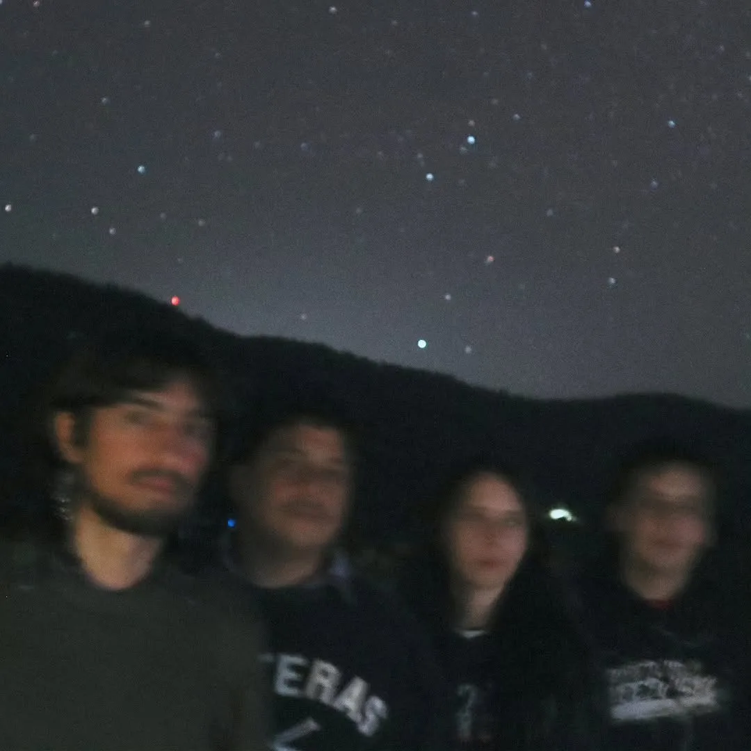 Los cuatro integrantes de Phuyu y la Fantasma de noche, bajo un cielo estrellado